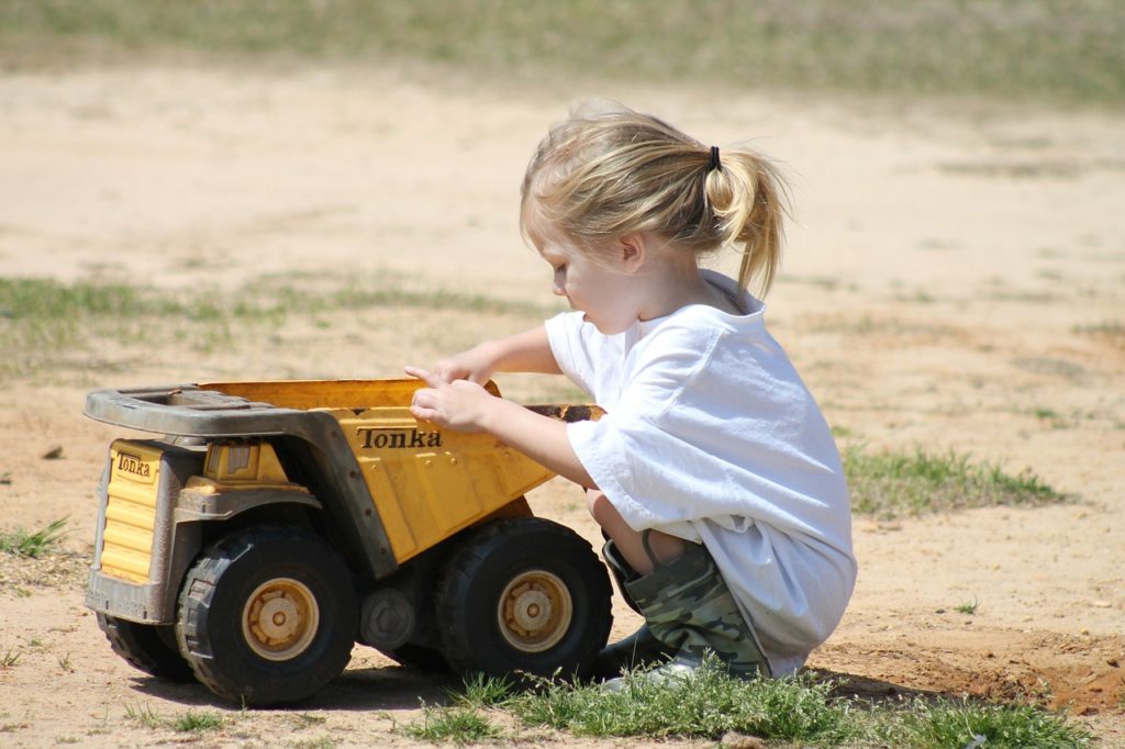 girl playing with truck outside