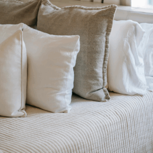 Cozy bedding with pillows and lamp