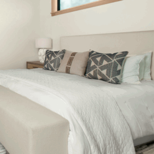 Cozy bedding with pillows and lamp
